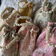 "These rich hand made artisanal Indian potli bags are embroidered on a dupion fabric, and are in a round \"bucket-esque\" shape. Though these bags can be used in place of a traditional clutch bag, they also make for a fantastic low-waste gift packing solution for weddings and life's other special events. This potli is embroidered all the way round, measures approximately 9x7 inches, and features a pearl embellished handle - resulting in a super rich luxurious look with a traditional twist Questi Luxury Pearl Embroidered Potli Pouch Bag, Luxury Bohemian Potli Bag For Festive Season, Cheap Rectangular Potli Bag For Festivals, Luxury Pearl Embroidered Bags For Gifts, Luxury Traditional Potli Bag With Pearl Embroidery, Luxury Potli Bag With Mirror Work For Festivals, Luxury Elegant Potli Bag In Pouch Shape, Pakistani Wedding Fevors Bids Dulha Dulhan. Dray Fruit Bags Dllls Dress Bag, Luxury Gift Bags With Round Handle