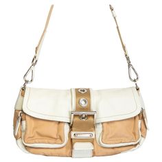 This bag features a cream and beige nylon body, leather trim and a front buckle to secure the top flap with magnetic snap closure. COLOR: Cream and beige MATERIAL: Nylon & leather ITEM CODE: 31 MEASURES: H 5.5” x L 10.5” x D 3.5” EST. RETAIL: $1200 COMES WITH: Dust bag CONDITION: Good - exterior shows general signs of wear such as wrinkling and the main interior zipper is disconnected. The interior is pristine and very clean. Small stain by zipper. Made in Italy --------------------------------- Designer Beige Flap Shoulder Bag, Designer Beige Flap Bag With Removable Pouch, Designer Beige Flap Bag With Detachable Strap, Designer Cream Shoulder Bag With Detachable Strap, Beige Flap Bag With Gold-tone Hardware, Modern Beige Flap Shoulder Bag, Cream Shoulder Bag With Leather Trim, Designer Cream Shoulder Bag With Adjustable Strap, Designer Beige Satchel With Adjustable Strap