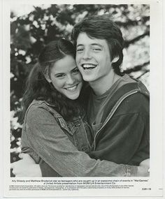 black and white photograph of two people hugging each other with trees in the back ground