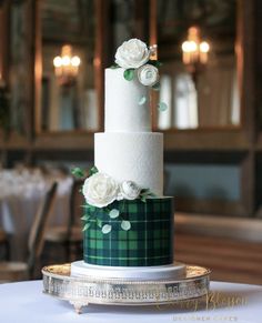 a white and green wedding cake sitting on top of a table