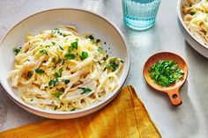 two bowls of pasta with parsley on the side