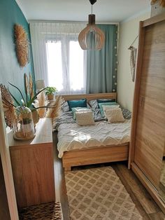 a bed room with a neatly made bed next to a wooden door and window sill