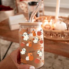 a person holding a glass with a straw in it and halloween stickers on it