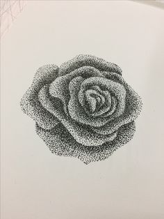 a black and white photo of a rose made out of small dots on the side of a piece of paper