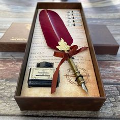 a pen, inkwell and stamp sitting in a wooden box on top of a table