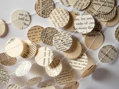 many pieces of paper with words on them are hanging from a string that has been made out of old book pages