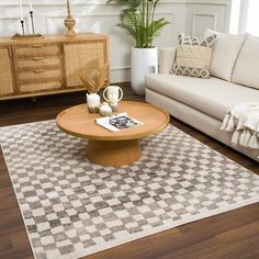 a living room with two couches, a coffee table and a rug on the floor