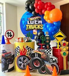 a birthday party with balloons and cars on the table in front of a sign that says lucas trucks 5