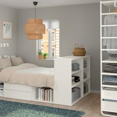 a white bed sitting next to a window in a bedroom