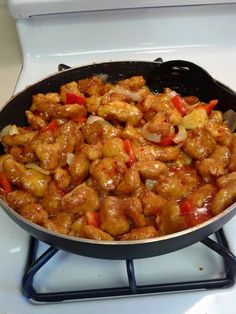 a pan filled with chicken and vegetables on top of a stove