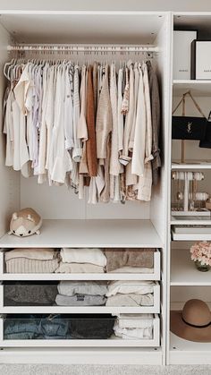 an organized closet with clothes, shoes and handbags on shelving units in white