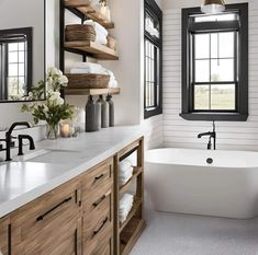 a bathroom with a tub, sink, and shelves in the wall next to it