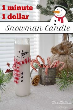 a snowman candle sitting on top of a table next to some candy canes