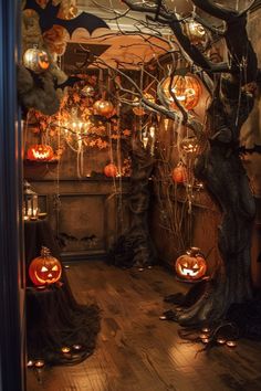 halloween decorations in the corner of a room with pumpkins hanging from it's branches