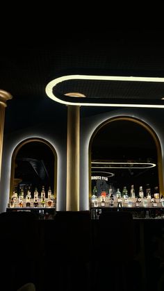 an empty bar is lit up at night with round lights on the ceiling and columns