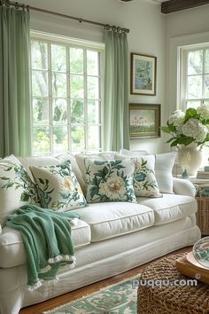 a living room filled with lots of furniture and windows covered in green drapes next to a white couch