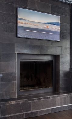 a fireplace with a painting on the wall above it