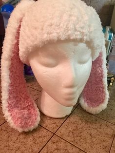 a white hat with pink ears on top of a table