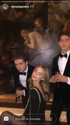 three people in tuxedos are posing for a photo with a painting behind them