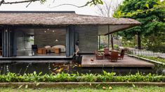 a small house with a thatched roof next to a pond