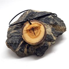 Show your love of nature with this natural tree slice pendant engraved with our original dragonfly design. In many cultures the Dragonfly is a symbol of adaptability and change. This is derived from the Dragonfly's ability to be at home in both water and air and its omnidirectional flight. *This wooden pendant is created with locally sourced wood and treated with mineral oil to preserve and hydrate the wood. *Comes with 20 inch waxed cord with a 2 inch chain extender for adjustable length. Dimen Adjustable Natural Wood Necklace Nature-inspired, Nickel-free Natural Jewelry As Gift, Nickel-free Jewelry As A Gift, Natural Color Necklace For Gift, Natural Round Necklace For Gift, Round Natural Color Necklace As Gift, Round Necklace In Natural Color For Gift, Spiritual Natural Wood Jewelry Gift, Natural Wood Pendant Jewelry Gift