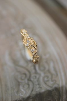 ✵ Learn more about us: www.edengardenjewelry.com ✵ WhatsApp number for urgent questions: +34 690 701 654 E-mail: edengardenshop@gmail.com This nature wedding band features delicate design with realistic looking twig and three leaves. Natural diamonds are placed on a textured shank and gives a nice sparkle. It is a dainty jewelry piece but sturdy enough for everyday wear. Suitable as woman's wedding band and unique engagement ring as well. There is also a similar ring with one leaf: https://www.e Gold Nature-inspired Diamond Ring, Nature-inspired Yellow Gold Diamond Ring For Anniversary, Nature-inspired Anniversary Diamond Ring With Rose Cut Diamonds, Nature-inspired Yellow Gold Wedding Diamond Ring, Nature-inspired Diamond Promise Ring, Nature-inspired Diamond Ring With Rose Cut Diamonds, Branch Wedding Band, Nature Wedding Band, Wedding Band With Diamonds