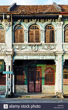 an old building with wooden shutters and windows on the street corner in front of it