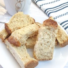 several pieces of bread on a plate next to a cup