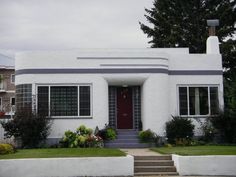 a white house with red door and steps leading up to it