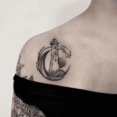 a woman with a lighthouse tattoo on her shoulder