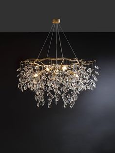 a chandelier hanging from the ceiling in a room with dark walls and flooring