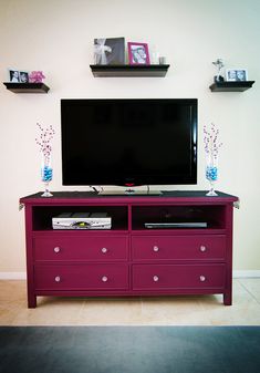 a flat screen tv sitting on top of a purple dresser