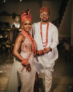 a man and woman dressed in traditional african garb posing for the camera with their arms around each other