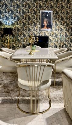 a dining room table with chairs and a laptop on top of it in front of a floral wallpaper