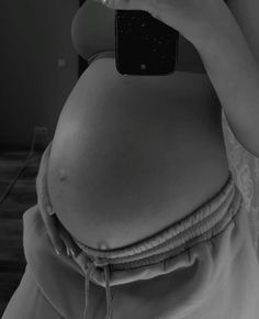 a pregnant woman taking a selfie with her cell phone