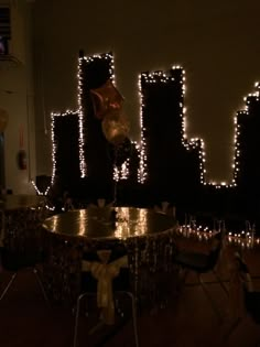 a table with balloons and lights on it in front of a cityscape at night