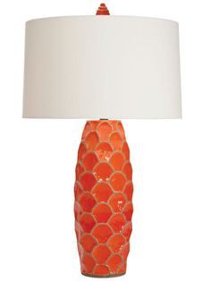 an orange ceramic lamp with a white shade