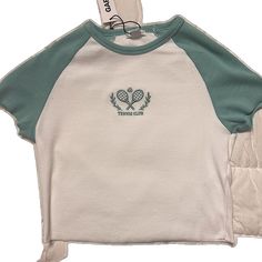 White Top With Embroidered Logo For Streetwear, Sporty Spring Tops With Embroidered Logo, Trendy Cotton Tops With Embroidered Logo, Casual White Tops With Embroidered Logo, Embroidered Green Tops For Streetwear, White Embroidered Crew Neck Top, White Crew Neck Top With Embroidered Graphics, Trendy Tops With Embroidered Logo For Spring, Trendy Spring Tops With Embroidered Logo