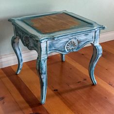 a small blue table sitting on top of a hard wood floor