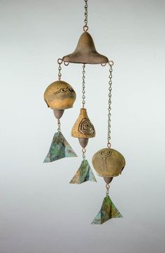 an artistic wind chime with three different shapes and colors hanging from it's chain