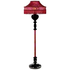 a lamp that is on top of a stand with a red shade over the base