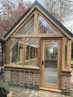 a small wooden building with glass doors and windows