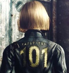 the back of a woman's head with short blonde hair, wearing a black leather jacket