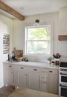 a kitchen with white cabinets and wooden floors