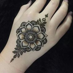 a woman's hand with a henna tattoo on it