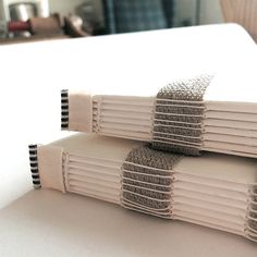 two stacks of folded papers sitting on top of a white table next to each other