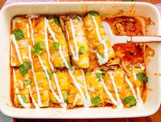 a casserole dish filled with mexican food and garnished with cilantro