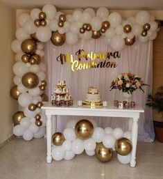 a table topped with white and gold balloons