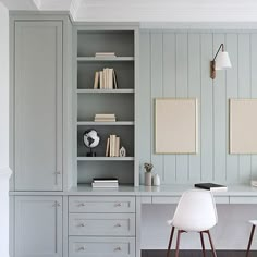 a desk with two chairs and bookshelves in front of it, next to an open bookcase