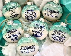 six glass ornaments that say christmas is in the air and have blue writing on them